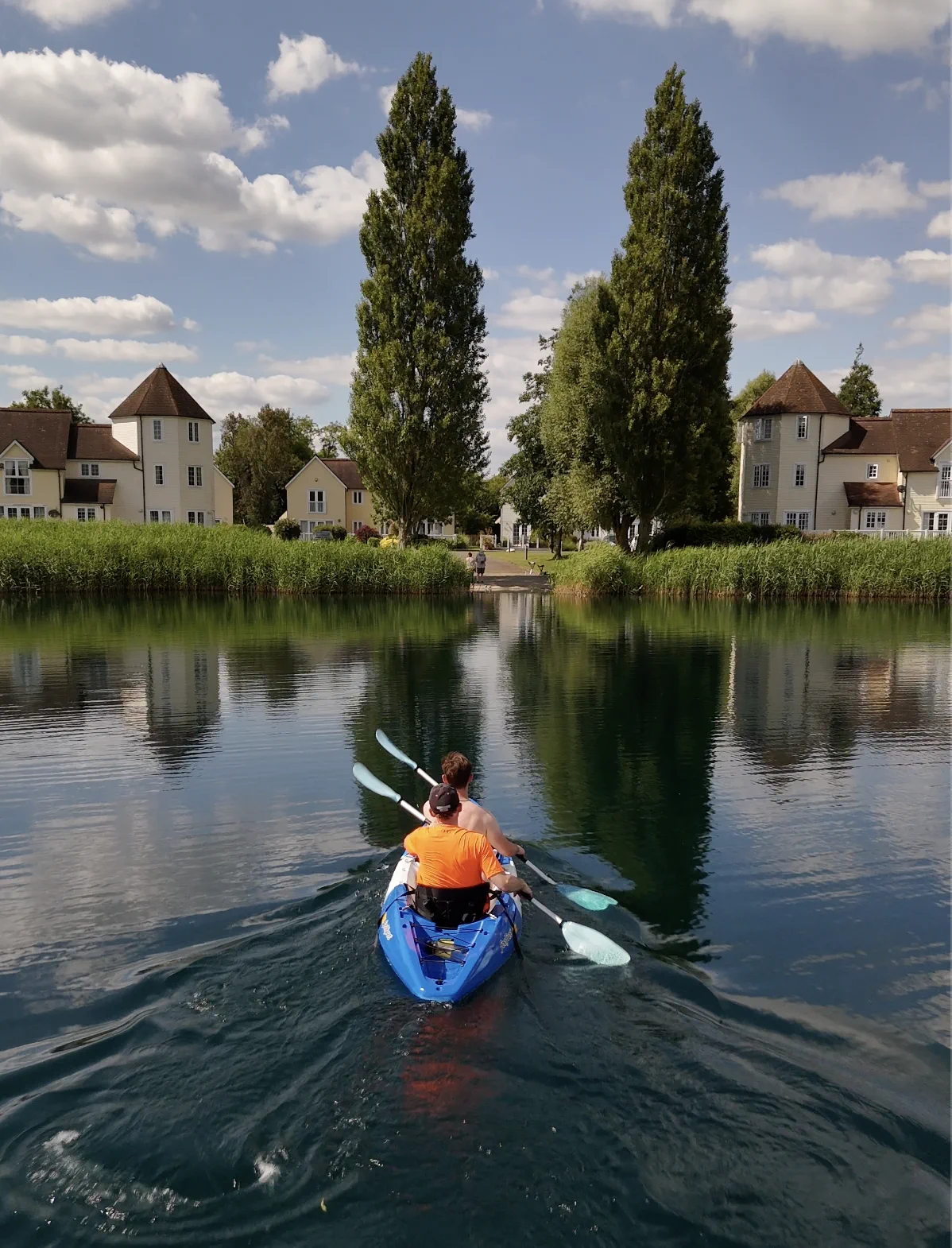 A two-person kayak on the lake heading back toward the lodges