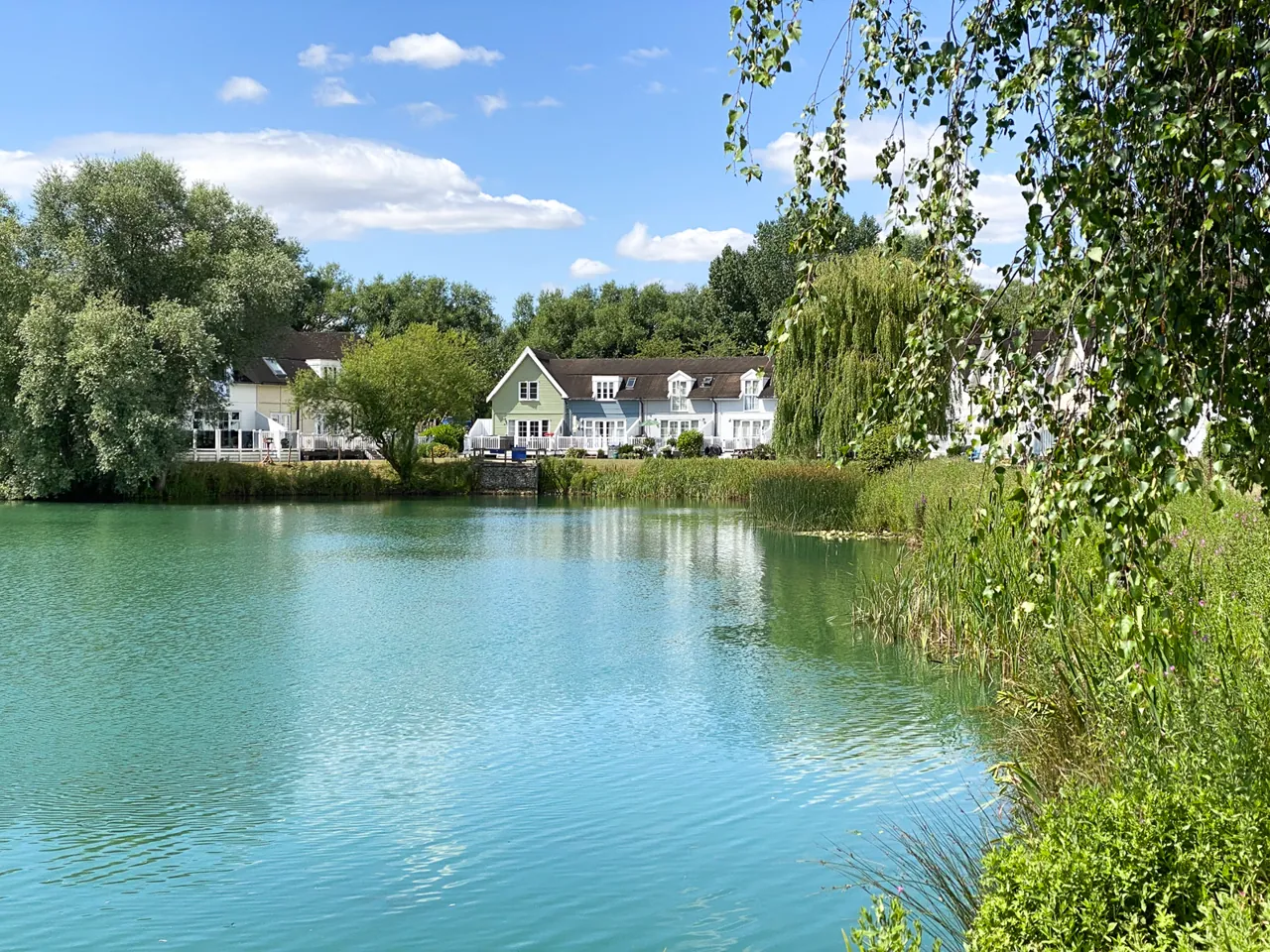 The turquoise water of Isis Lake with lodges nestled among the trees beyond