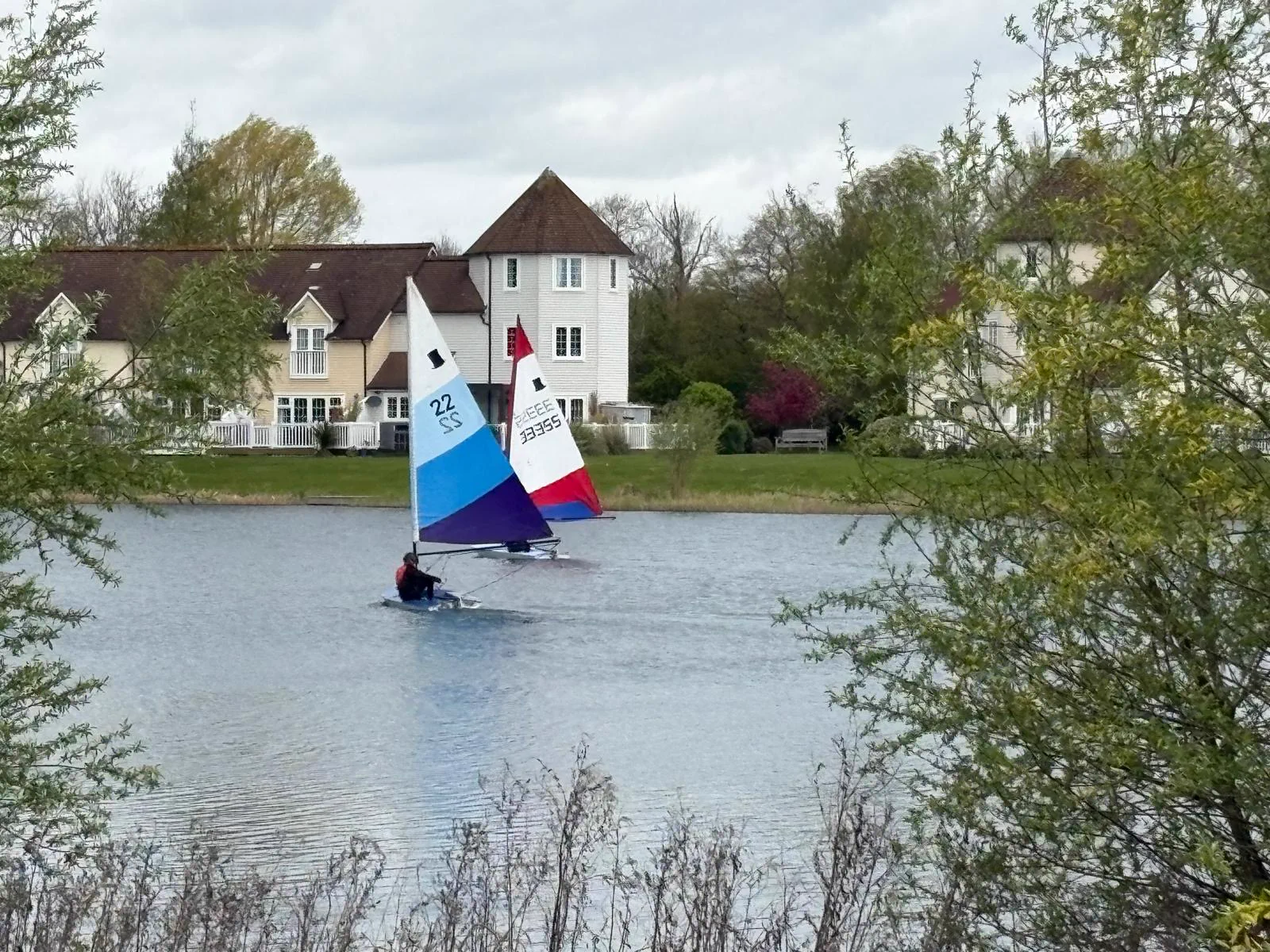 A sailing dinghy out on Windrush Lake